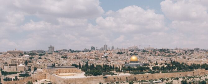 Yfirlitsmynd af Jerúsalem, blár himinn á efri helming myndarinnar og borgin við sjóndeildarhring á neðri hlutanum.